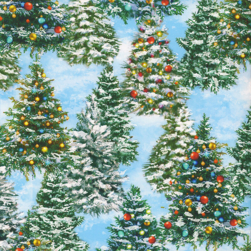 Bright blue and white mottled fabric with evergreen trees decorated with Christmas ornaments and white puff texture that resembles snow