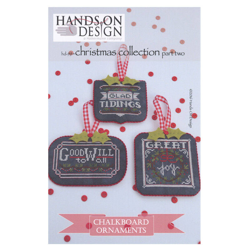 Front of pattern showing the completed cross stitch designs displayed on a white table with scattered red buttons.