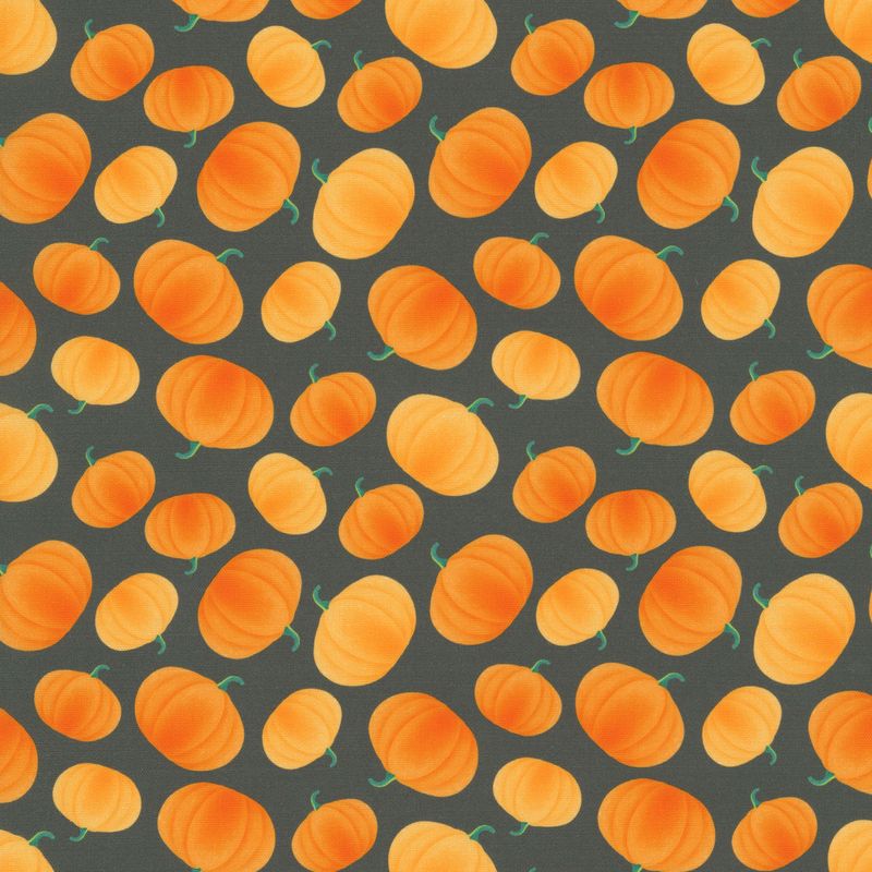 Charcoal gray fabric with a tossed pattern of shaded orange pumpkins