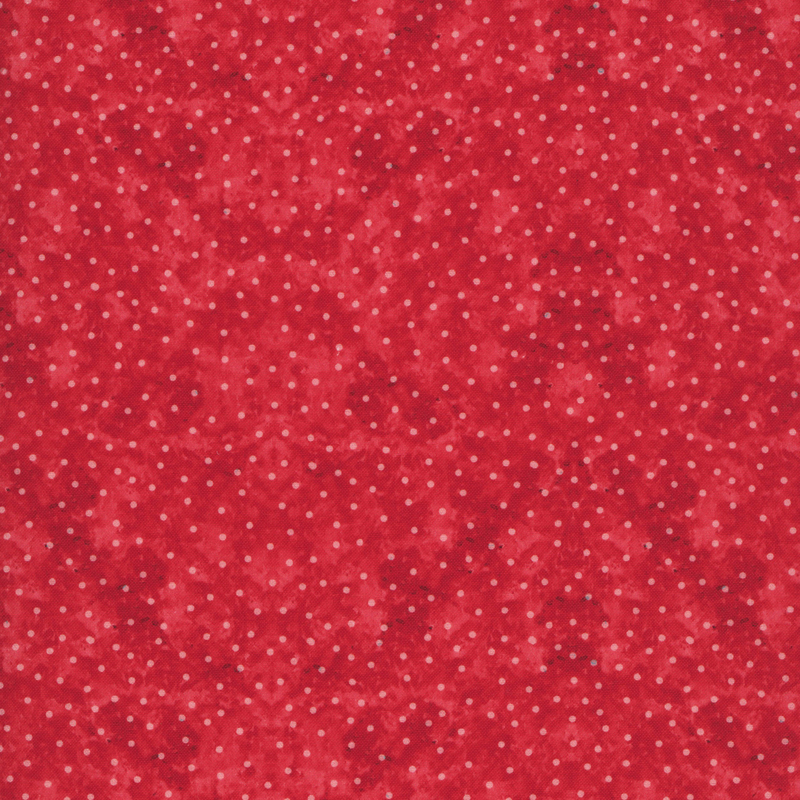 White polka dots on mottled red fabric.