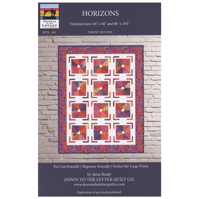 Horizons quilt by Down to the Letter displayed on a brick wall, featuring geometric patterns.