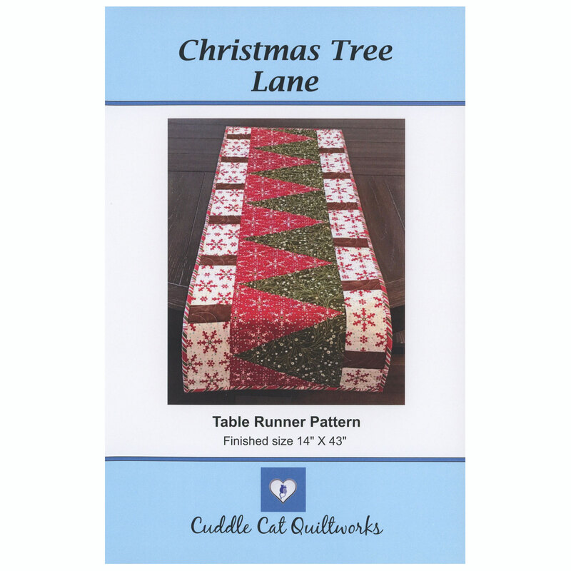 The front of the Christmas Tree Lane table runner displayed on the edge of a dark wood table.