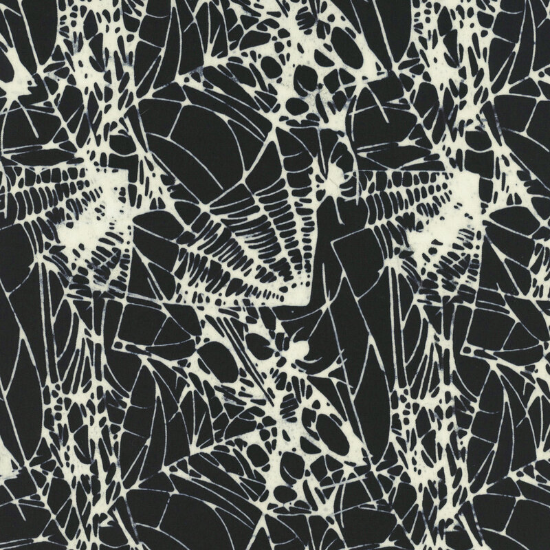 Black fabric covered in white spider webs.