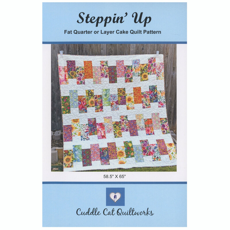 The front of the Steppin' Up quilt pattern displaying the finished product against a wood fence.