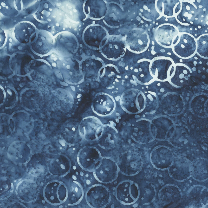 Mottled white and indigo fabric with a pattern of tonal watercolor circles and drops