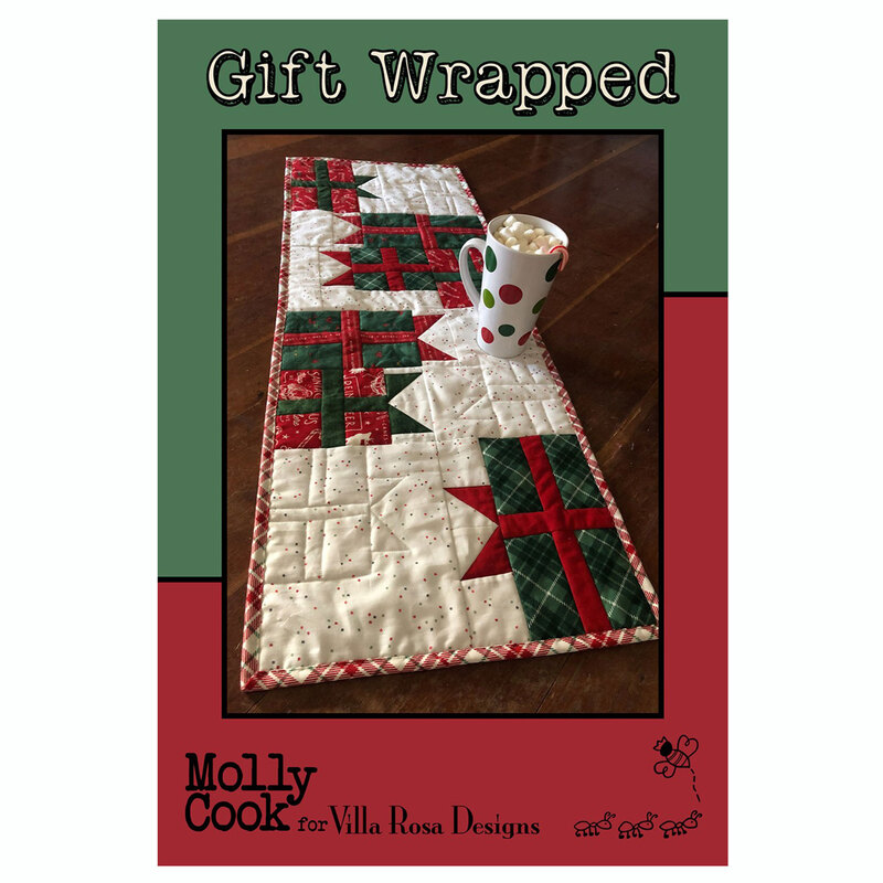 The front of the Gift Wrapped table runner pattern showing the completed project on a table with a festive mug.