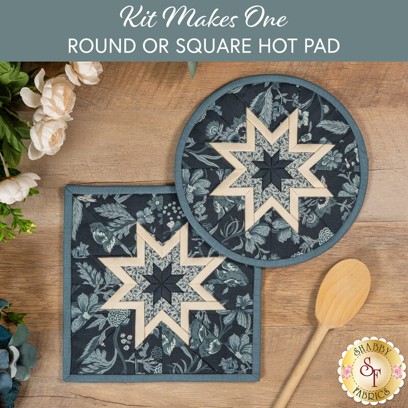 The two completed dark blue Folded Star Hot Pads, one round and one square, slightly overlapping each other and staged on a wooden table with coordinating décor.