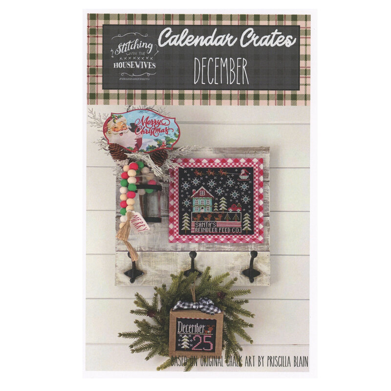 The front of the Calendar Crates December cross stitch pattern showing the completed project featuring gingerbread babies and houses surrounded by coordinating holiday décor. 
