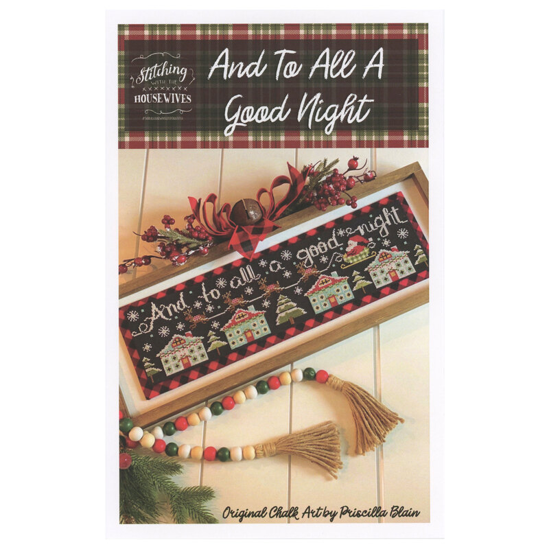 The front of the And To All A Good Night cross stitch pattern showing the completed project surrounded by coordinating holiday décor. 