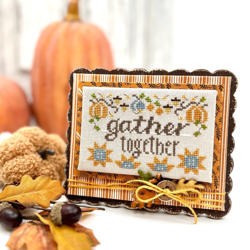 The fully assembled and painted Super Simple Scallop Cross Stitch Frame, staged on a white tabletop with coordinating fall decor, displaying a Thanksgiving-themed project.