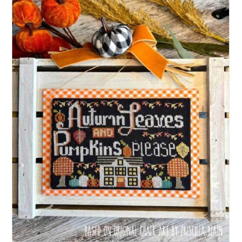 A framed cross-stitch art piece with the text Autumn Leaves and Pumpkins Please, featuring pumpkins and a house design, set against a rustic background with decorative elements.