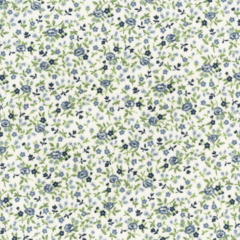 Navy and cadet blue flowers tossed amongst green sprigs and leaves on a white fabric.