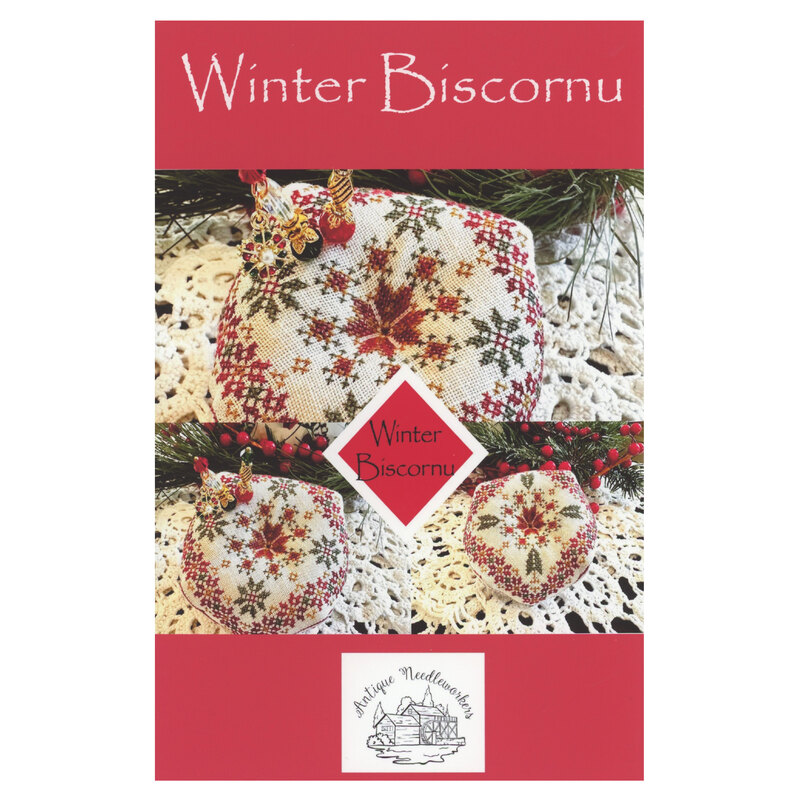 The front of the Winter Biscornu cross stitch pattern showing the completed project staged with coordinating decor.