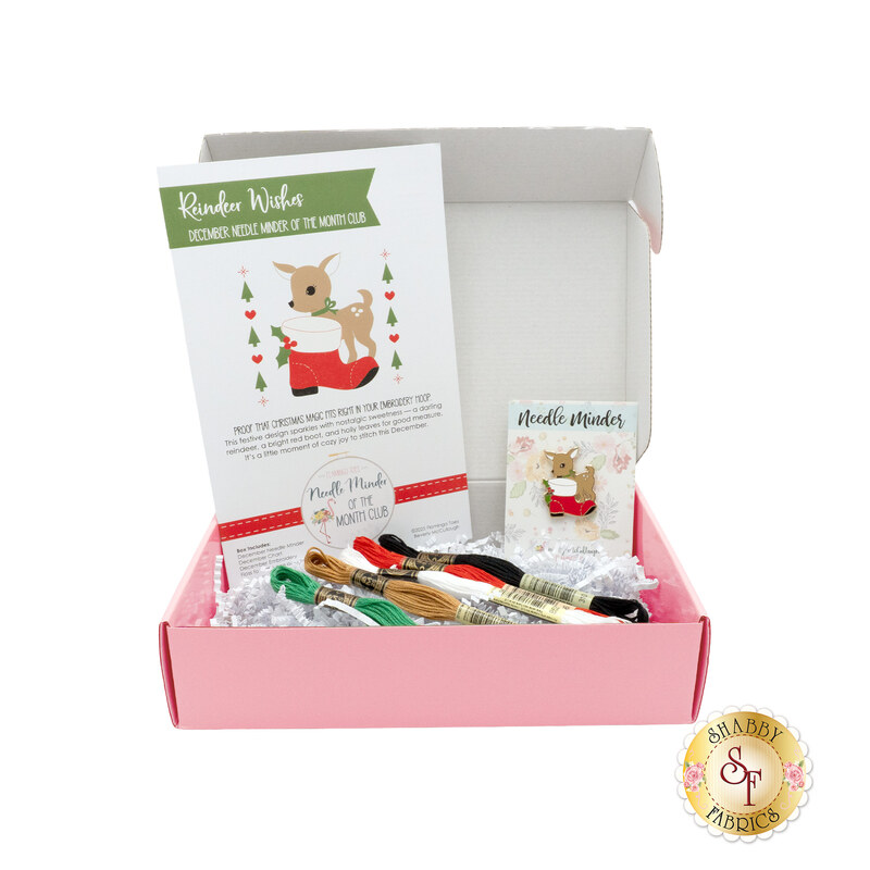 The December Needle Minder of the Month box, open and showing the contents, from the pattern to the floss and needle minder.