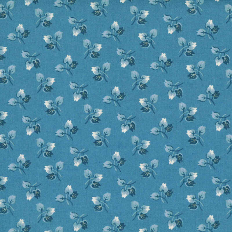 A vintage pattern of small floral buds in navy blue, light blue, and cream on a denim background