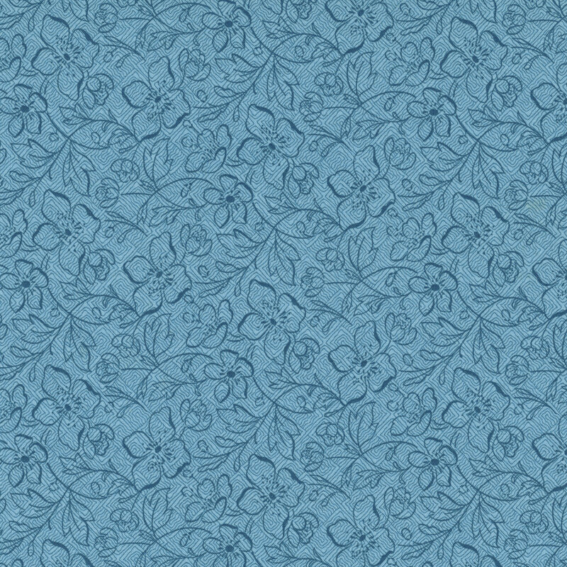 A textured denim blue fabric with a stylized pattern of flowers and vines