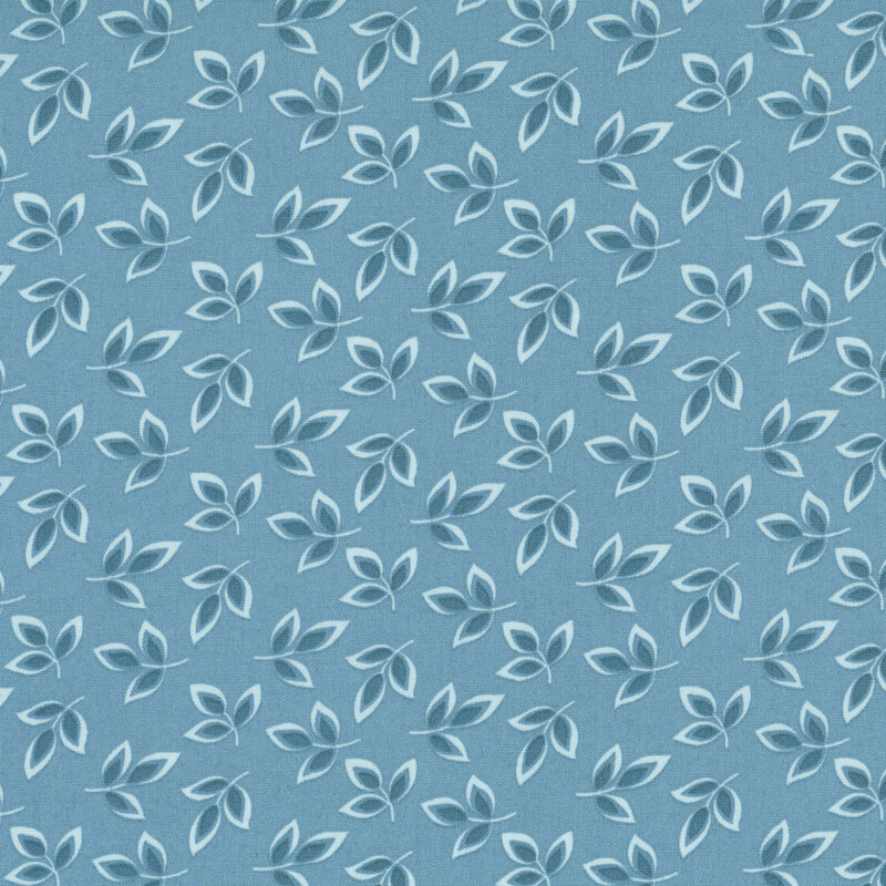 Denim blue fabric with a dense pattern of light blue and navy leaves 