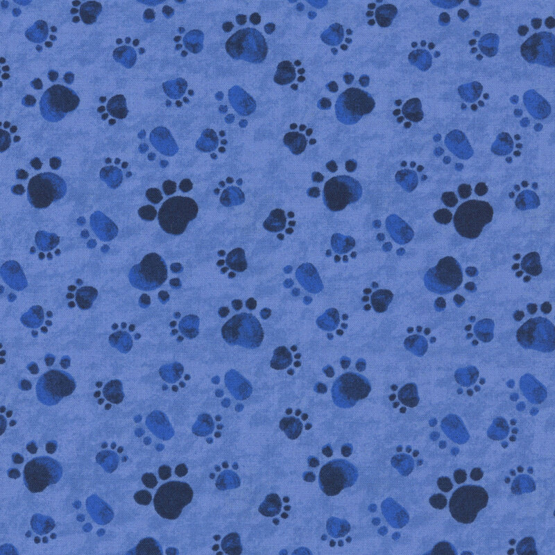 mottled blue fabric with a tossed pattern of paw prints in navy.