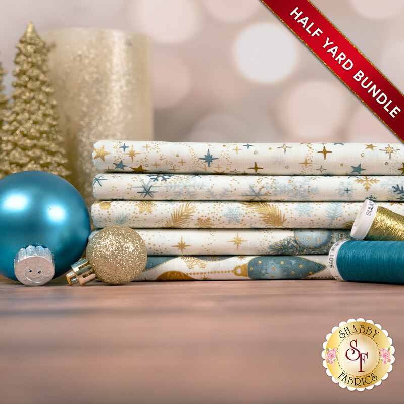 A stack of the five fabrics included in the 5 HY Bundle Cream Teal/Gold by Stof Fabrics, with ornaments, thread, and a candle.