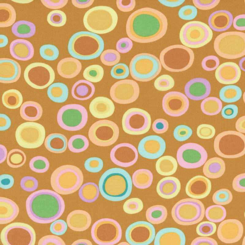 Honey yellow fabric featuring large, ringed polka dots in various colors.