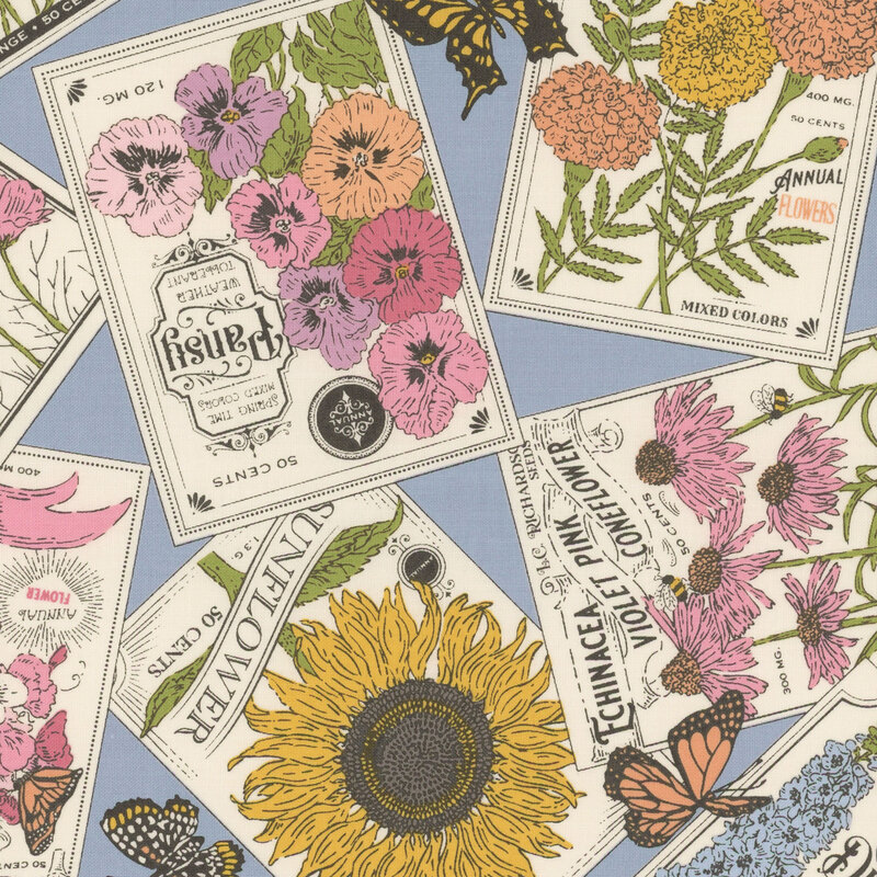 Vintage seed packets of common flowers and butterflies on blue fabric.