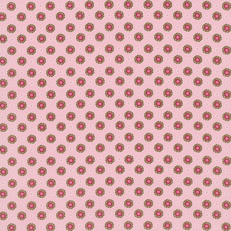 Pink fabric featuring evenly spaced floral medallions and white circle outlines.