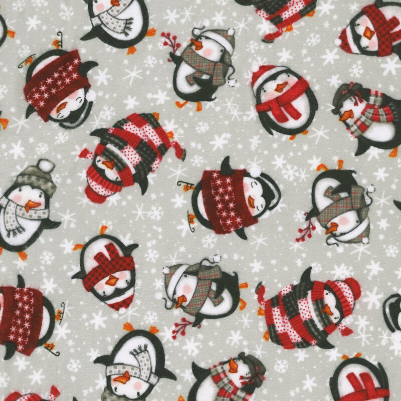 Gray fabric with a playful pattern of cartoon penguins dressed in winter clothes alongside snowflakes.