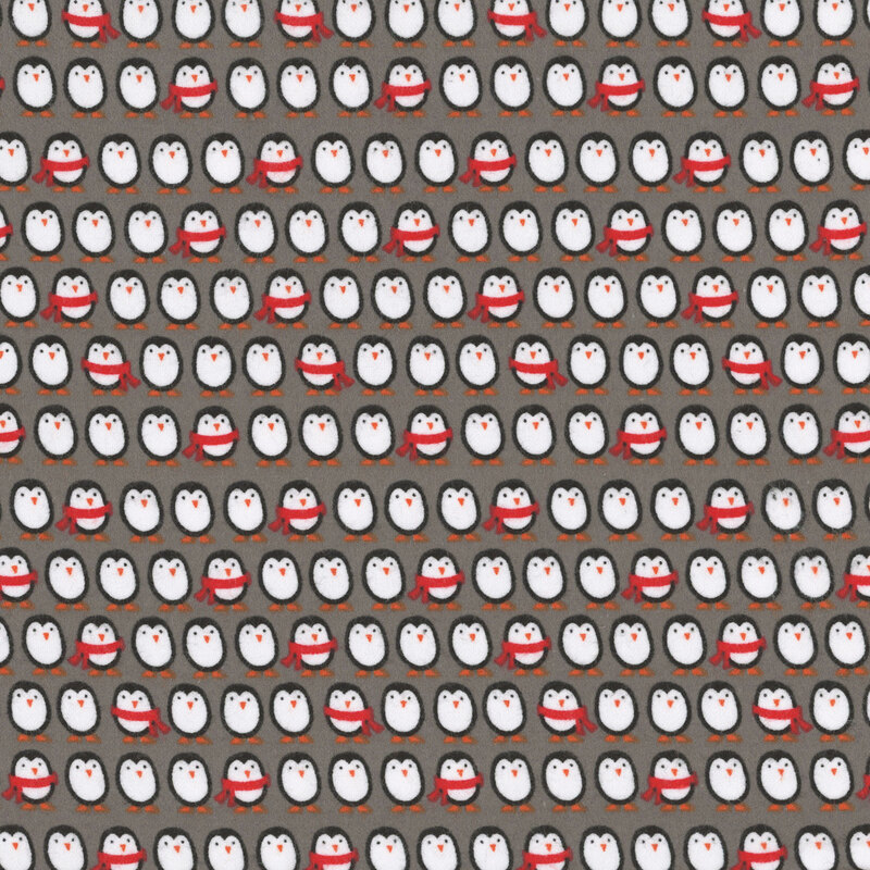 Dark gray flannel fabric with playful stripes of cartoon penguins dressed in winter clothing.
