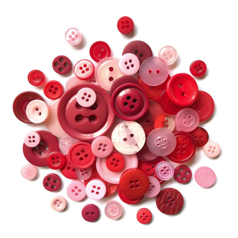 A variety of red and pink buttons in different sizes and styles clustered together on a white background.