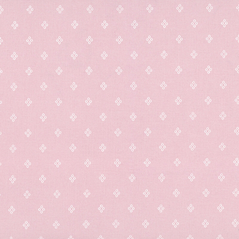 Pastel pink fabric with a pattern of white diamond shaped circles