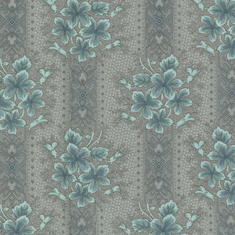 Slate gray fabric with a tonal dotted texture, blue and gray ornamental stripes, and light teal floral clusters 