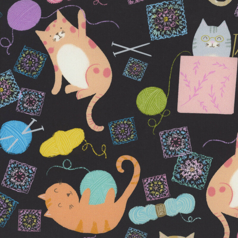 Black fabric featuring playful cats enjoying balls of yarn and granny squares.
