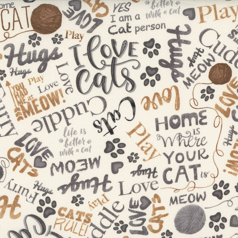 Pale beige fabric with cat-loving phrases in gray and gold colors, balls of yarn, and paw prints.