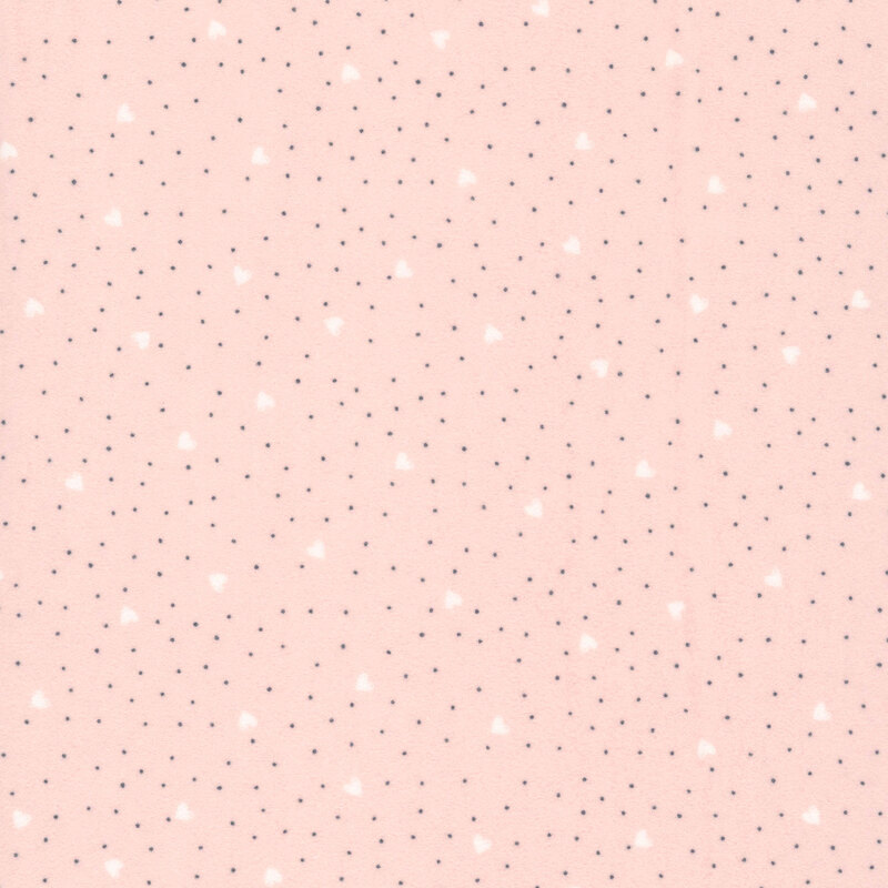 A pastel pink fabric with tossed white hearts and dark polka dots. 