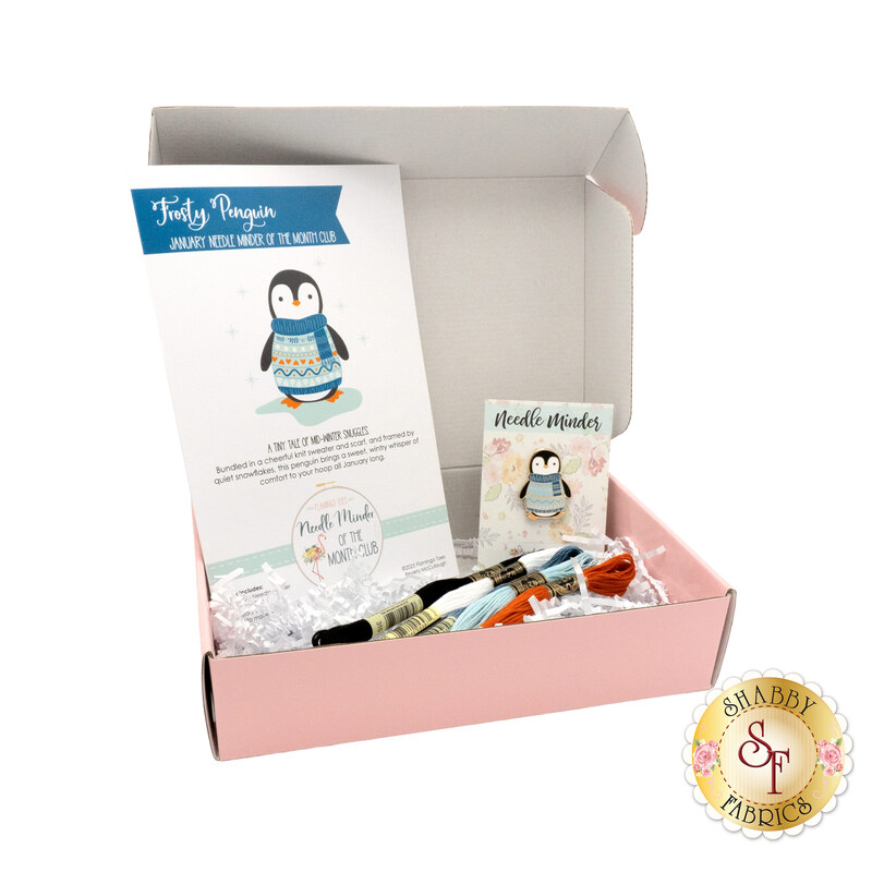 The January Needle Minder of the Month box, open and showing the contents, from the pattern to the floss and needle minder.