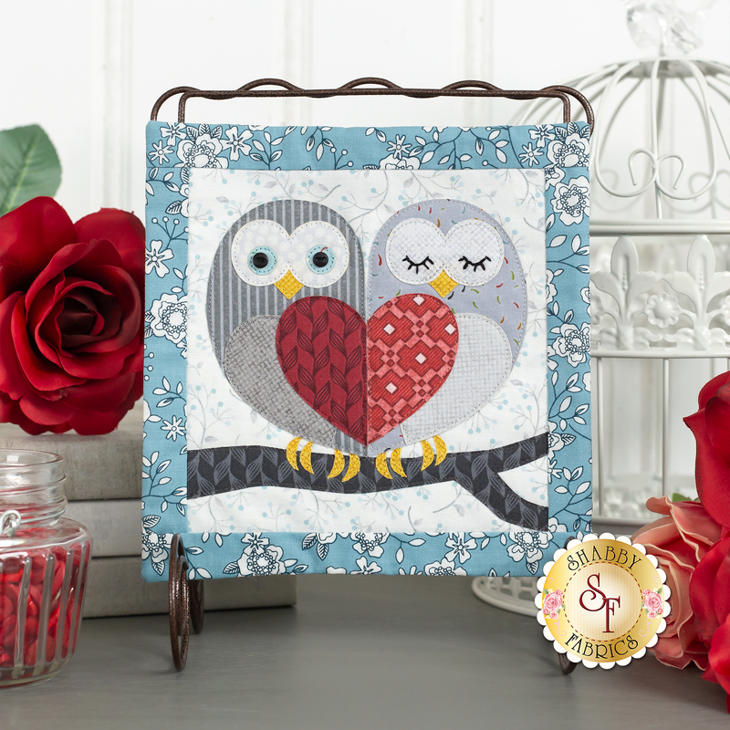 The On Wander Lane Mini Quilt - Loveland Cottage - Owl Love You Kit featuring a pair of owls on a tree brach with wings that come together in the shape of a heart.