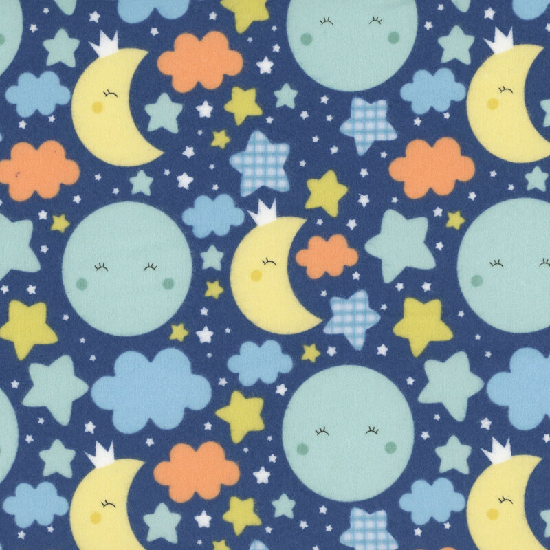 Navy fabric with cute, blushing turquoise suns and yellow moons amid orange, blue, and yellow colored stars and clouds.