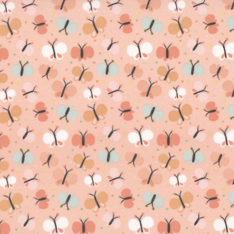 Peach pink fabric with a pattern of cartoonish butterflies in coral, orange, turquoise, and white