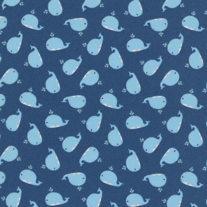 Navy blue fabric with tiny blue pindots and a ditsy pattern of cute blue whales