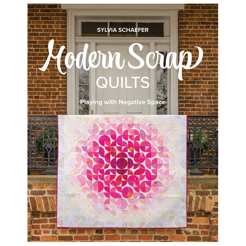 The front of Modern Scrap Quilts book featuring a quilt hanging on a front porch ornamental railing.