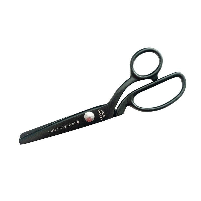 Black pair of scissors with ergonomic handles and a safety red dot on the blade.