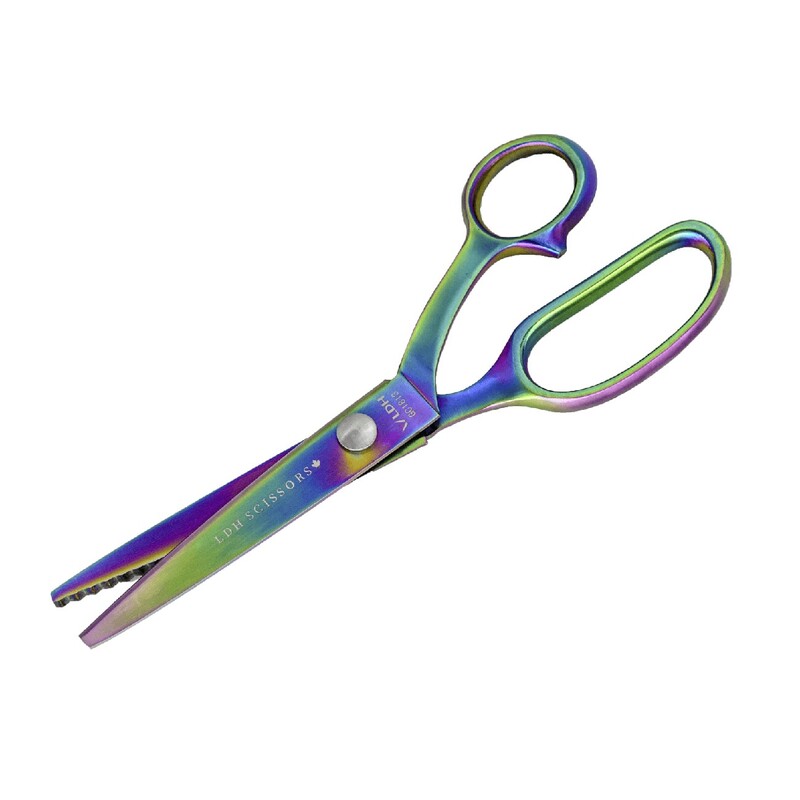 Rainbow-colored scissors with a straight and serrated edge, featuring a blue handle.