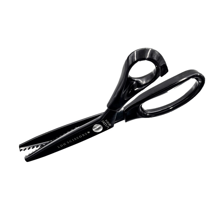 Black scissors with a serrated edge and ergonomic handles on a white background.