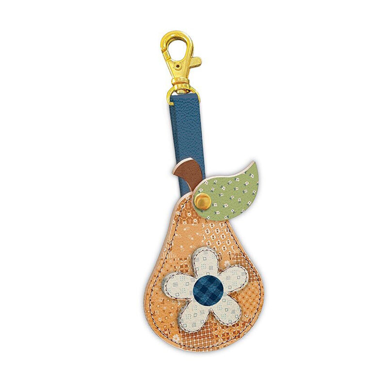 Leather pear charm, made with blue, tan, cream, and green colored leather, with a gold toned clasp against a white background