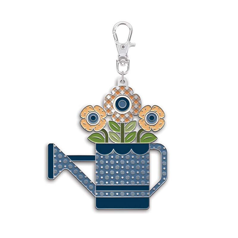 Blue enamel watering can with daisies charm on a white background