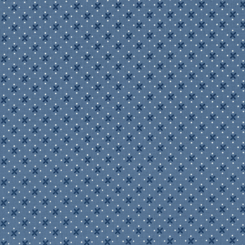 A simple pattern of navy blue x's and white dots on a faded blue denim background