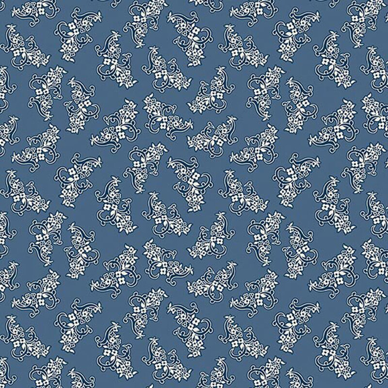 Faded blue fabric with a pattern of ornamental navy blue and white floral motifs