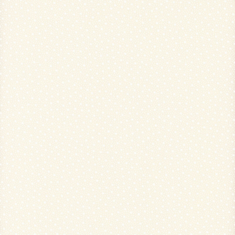 White on cream muslin fabric featuring very tiny snowflakes.