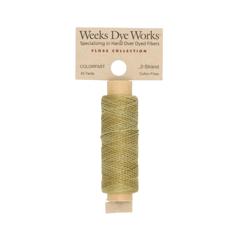 A spool of khaki embroidery floss with a tan label featuring the brand name and color information.