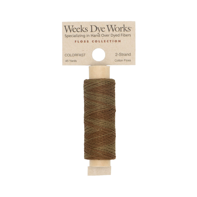 A spool of brown embroidery floss with a tan label featuring the brand name and color information.